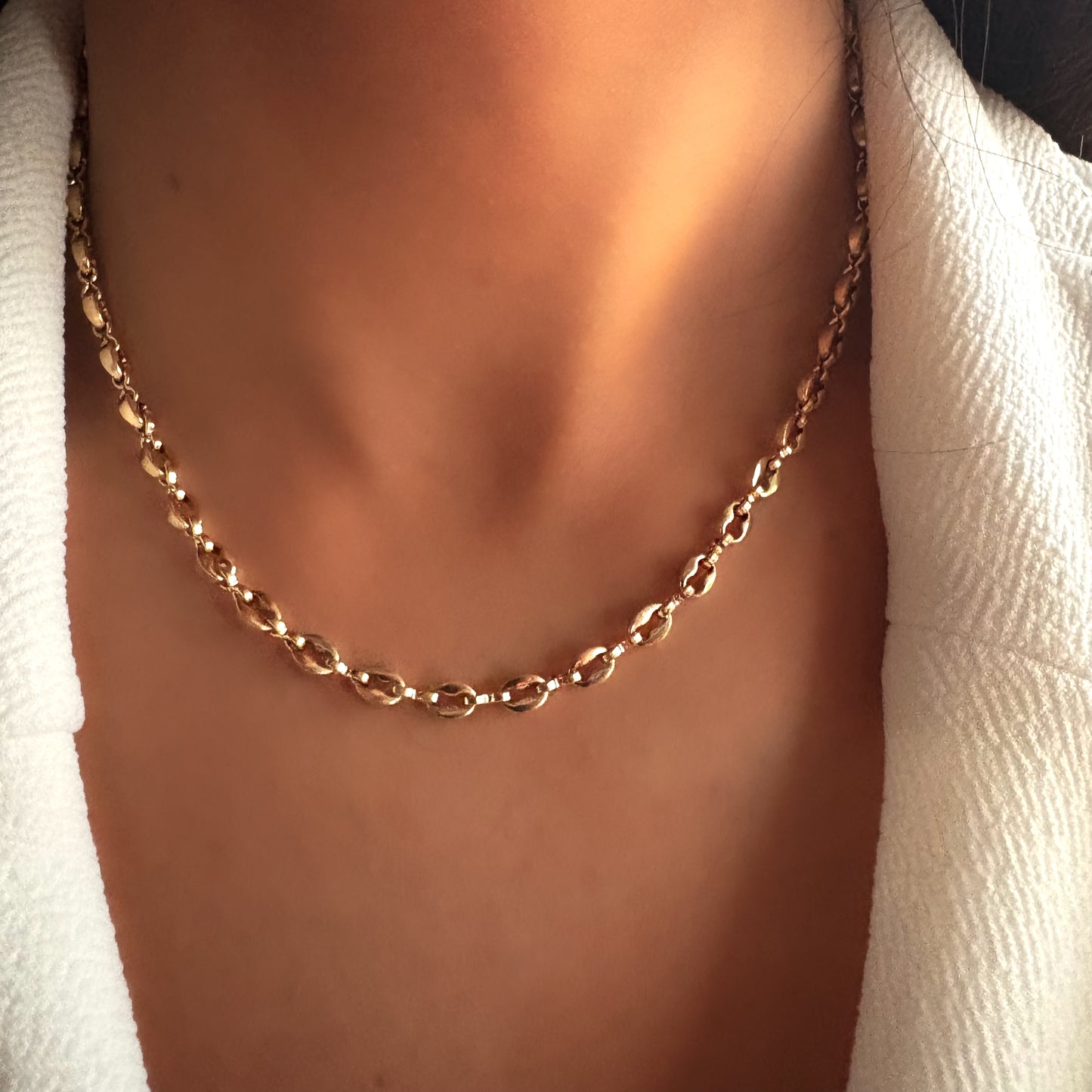 Collier chaîne à maillons ovales porté au cou, bijou élégant en acier inoxydable au design intemporel, mettant en valeur le décolleté avec sobriété.