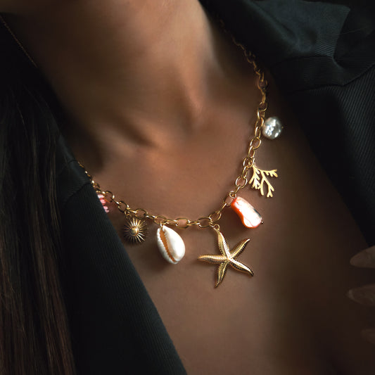 Collier doré tendance avec pendentifs marins : étoile de mer, coquillage et corail