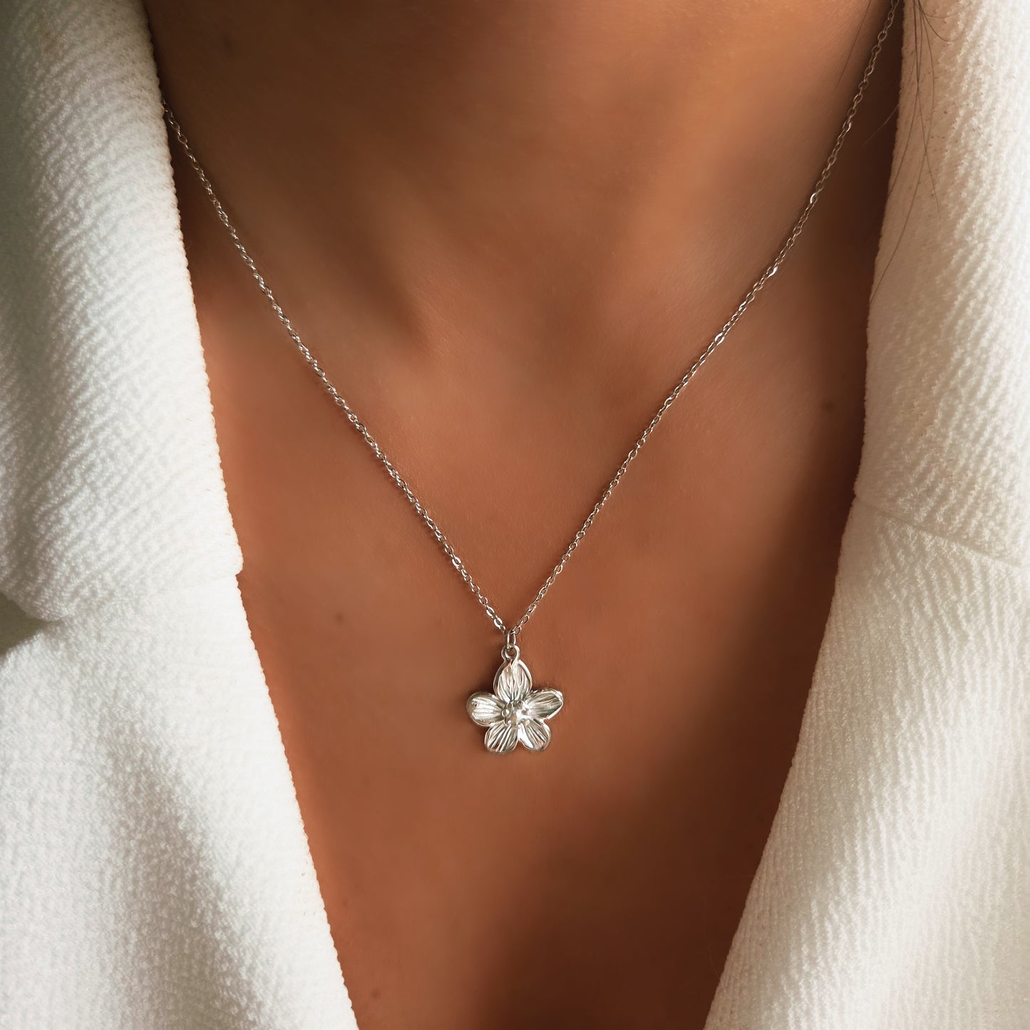 Collier pendentif fleur minimaliste porté au cou, bijou floral élégant et raffiné