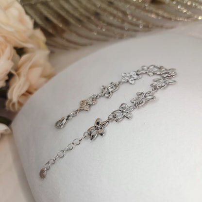 Bracelet fleurs ajourées présenté à plat, montrant l’alignement harmonieux des motifs et la chaîne d’ajustement.