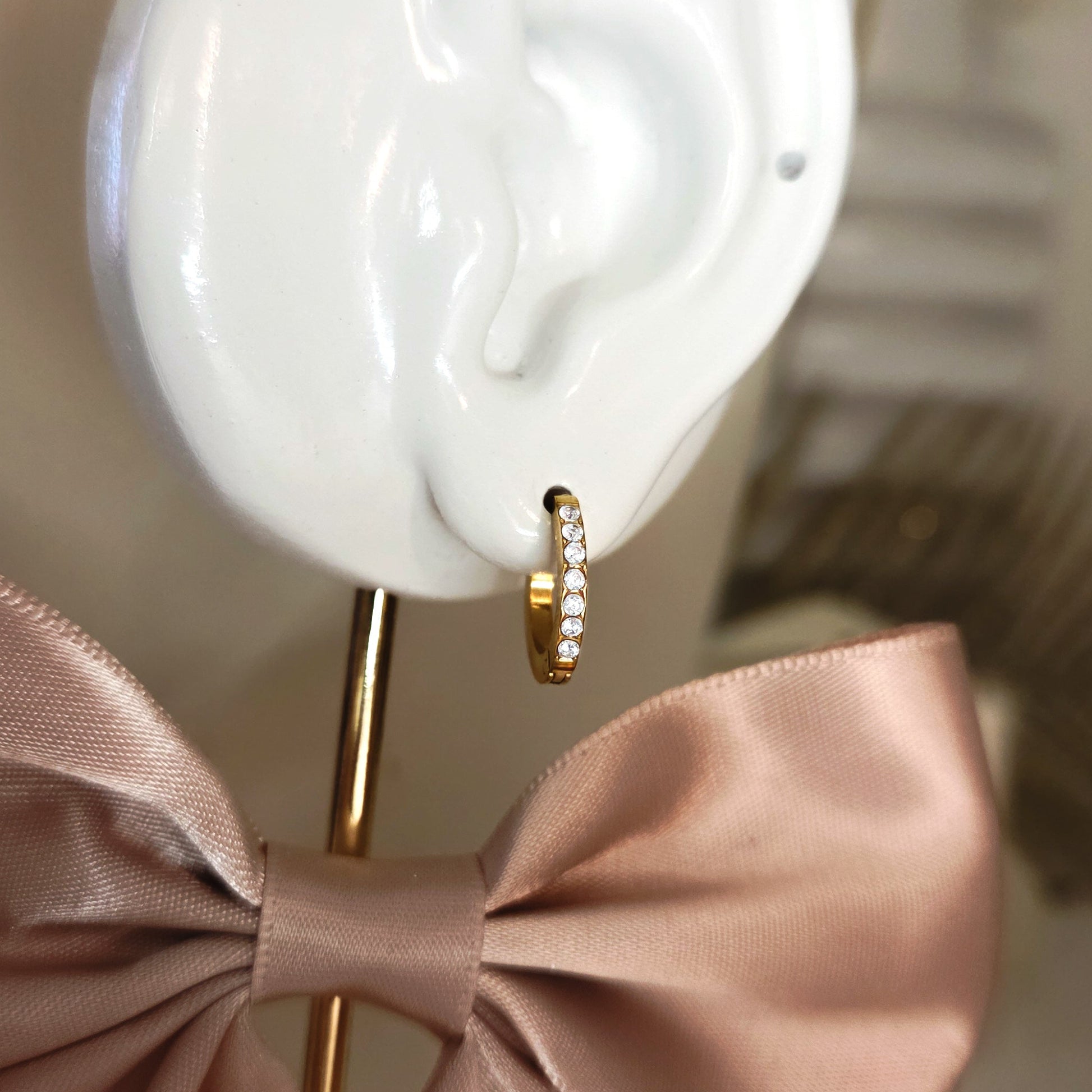 Paire de boucles d’oreilles créoles fines serties de cristaux portées à l’oreille, bijou élégant et minimaliste