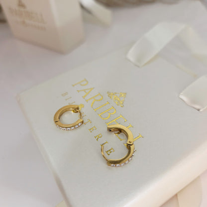 Paire de boucles d’oreilles créoles fines serties de cristaux portées à l’oreille, bijou élégant et minimaliste zoom sur les détails du fermoir