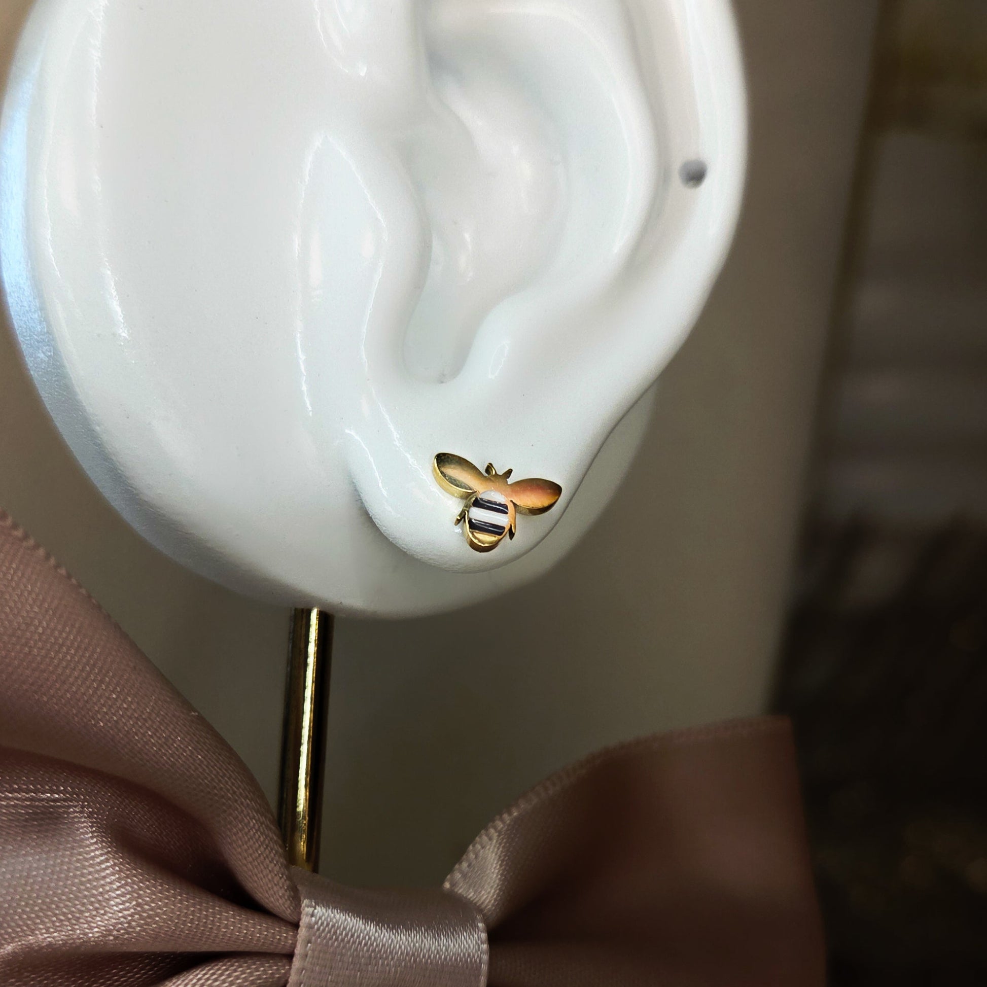 Paire de boucles d’oreilles puces en forme d’abeille portées à l’oreille, bijou délicat et symbolique