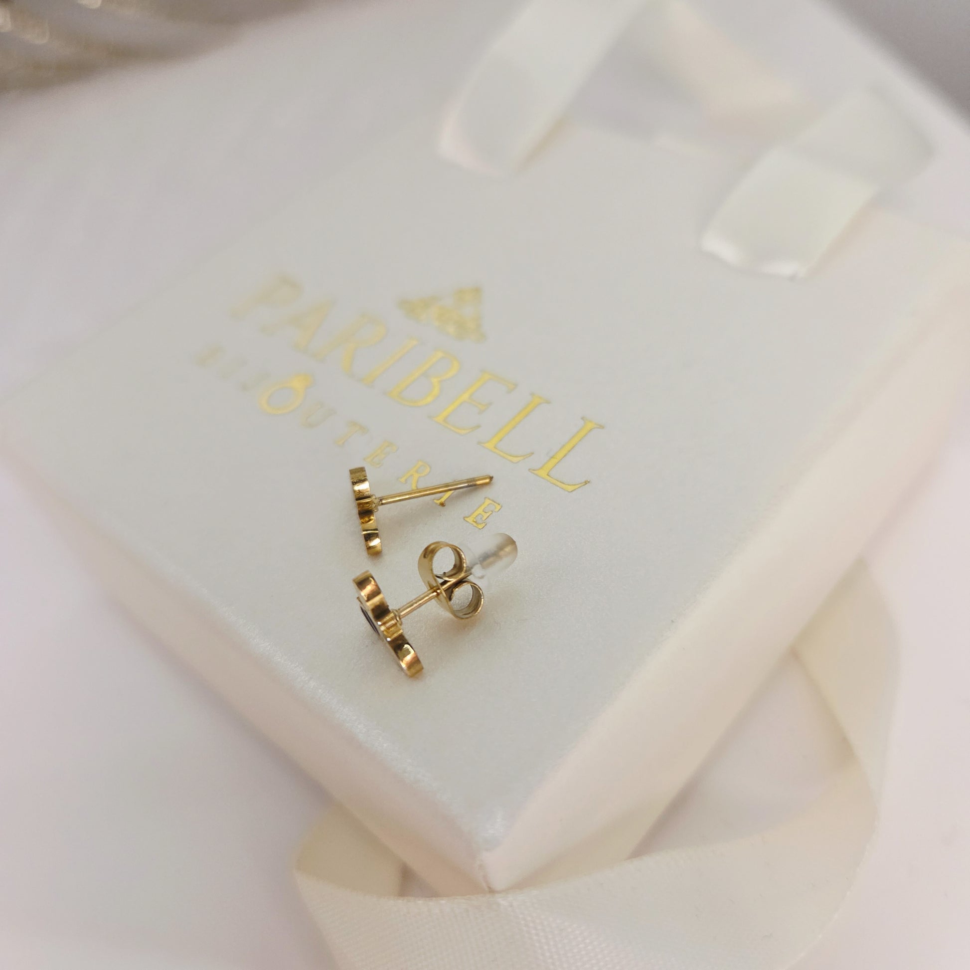 Paire de boucles d’oreilles puces en forme d’abeille portées à l’oreille, bijou délicat et symbolique et fermoirs