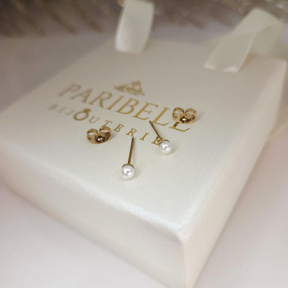 Paire de boucles d’oreilles puces avec perles portées à l’oreille, bijou minimaliste élégant et discret plus vue sur le détail des fermoires des boucles dorées