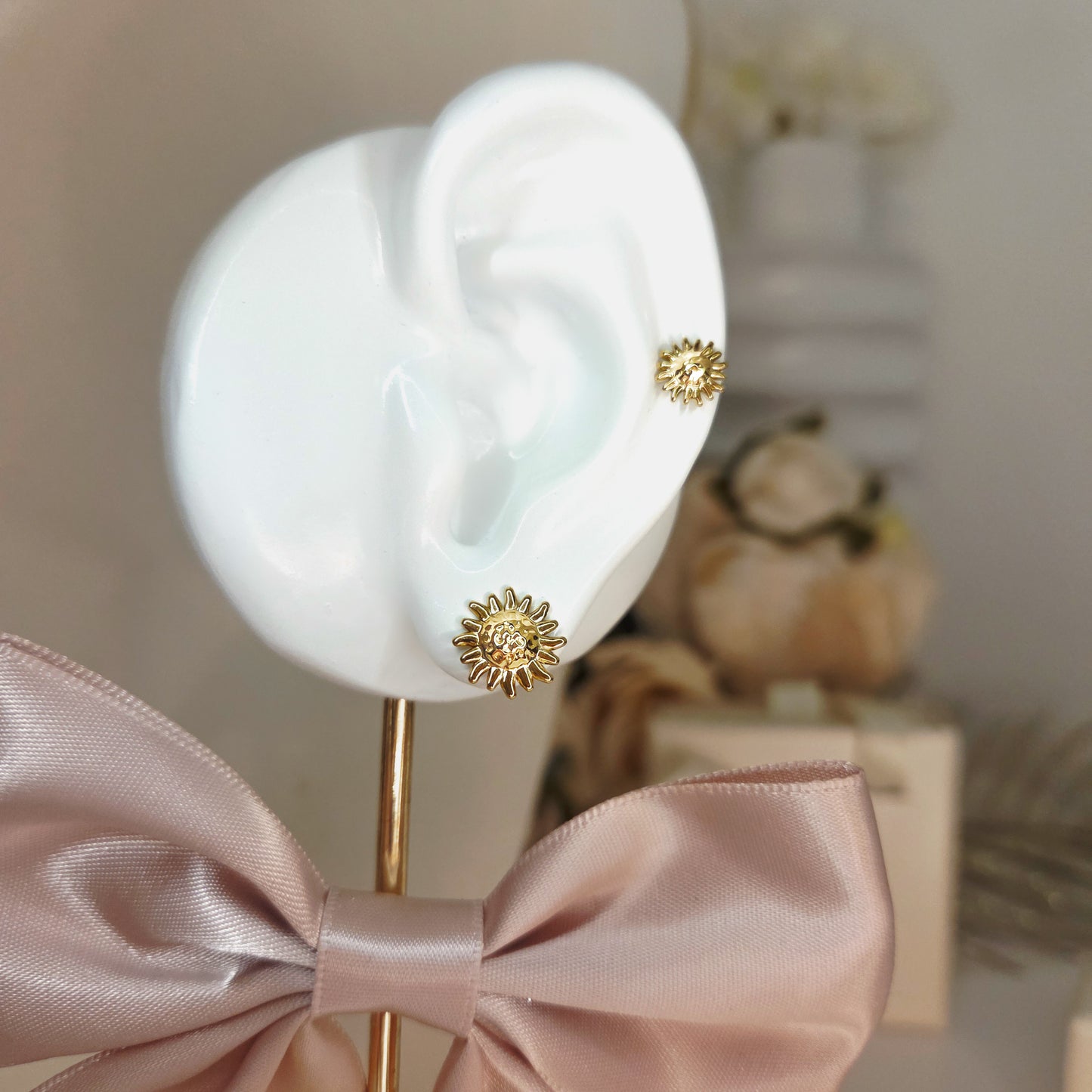 Paire de boucles d’oreilles puces motif soleil portées à l’oreille, bijou discret et symbolique