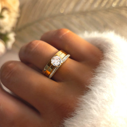 Ensemble de trois bagues pour femme en acier inoxydable doré, composé d’un solitaire et de deux anneaux ornés de strass. Bijoux résistants à l’eau et hypoallergéniques, parfaits pour un style chic et raffiné.