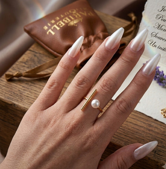 Bague dorée ajustable avec barre minimaliste et perle blanche portée à la main