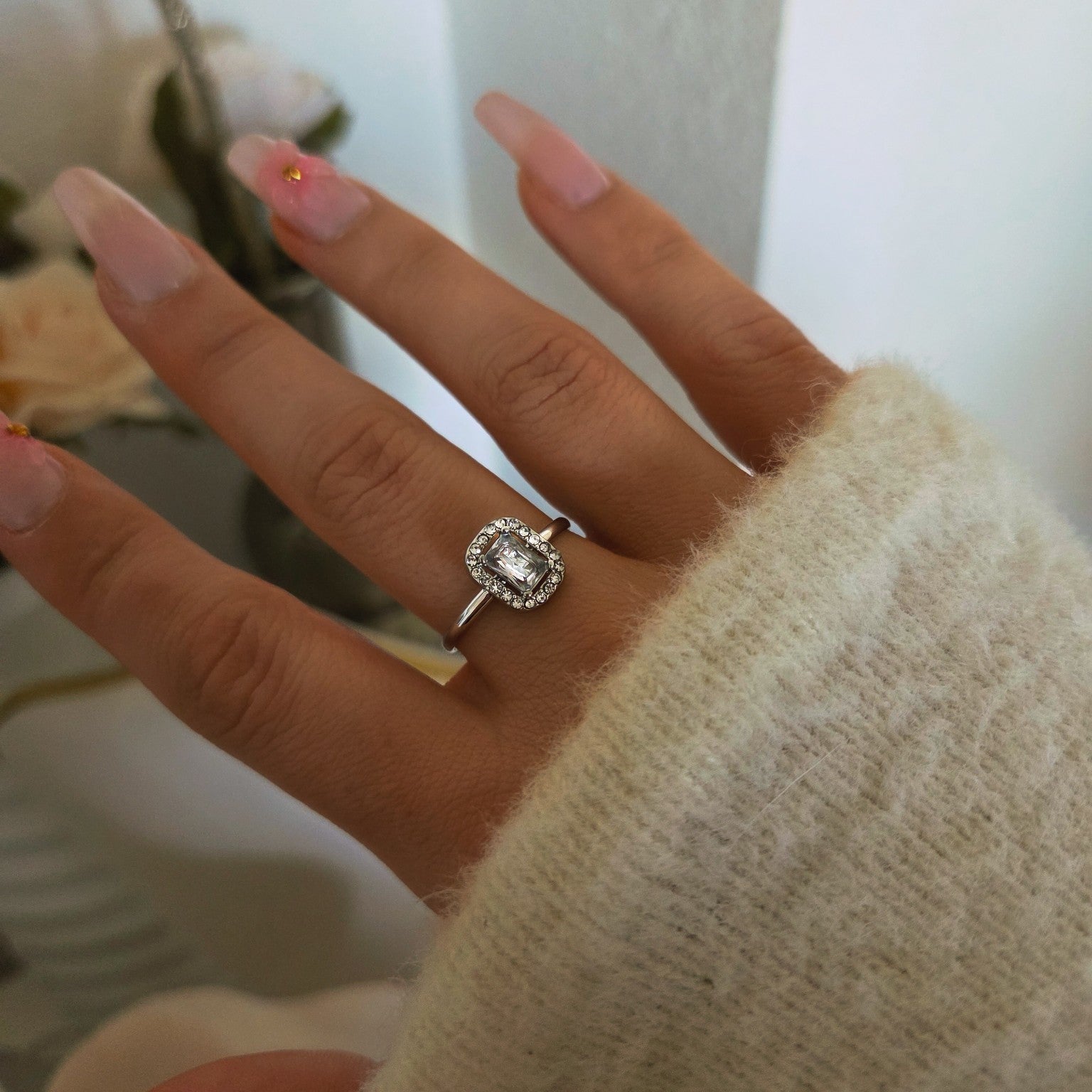 Bague carrée argentée portée sur la main