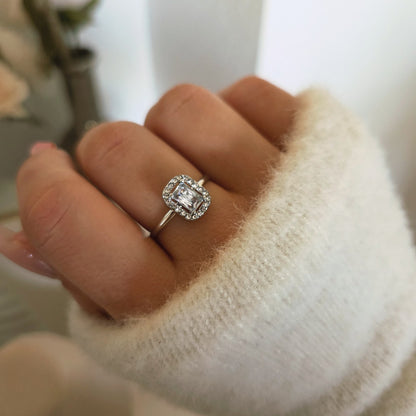 Bague carrée argentée sertie d'un cristal central et d'un halo de pierres portée