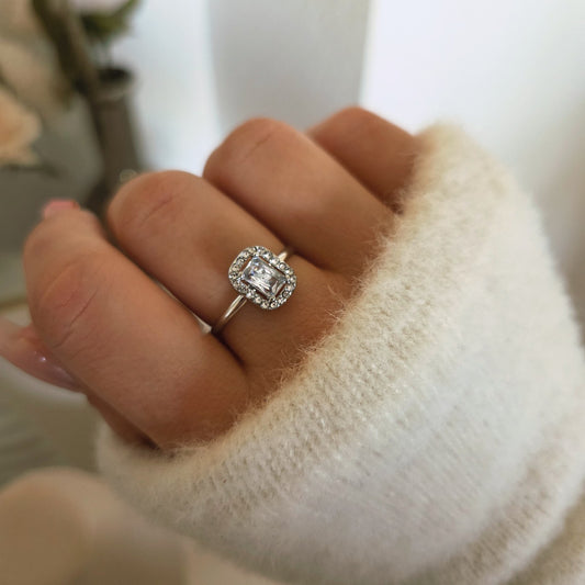 Bague carrée argentée sertie d'un cristal central et d'un halo de pierres portée
