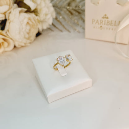 Bague Cléa en acier inoxydable doré avec deux pierres brillantes – Bijou ajustable sur présentoir blanc. Pierre en forme de goutte. Parfaite pour offrir ou se faire plaisir avec un bijou de qualité.