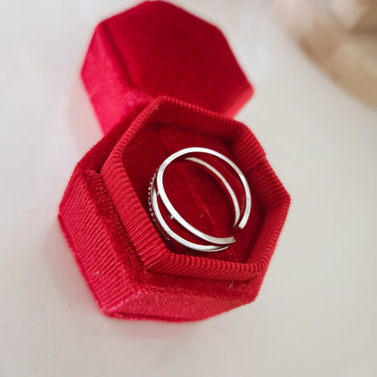 Vue arrière d'une bague croisée argentée réglable dans un écrin rouge