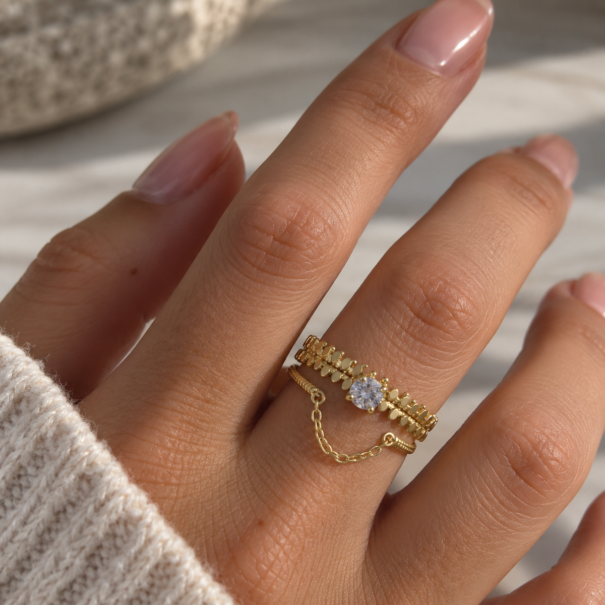 Bague dorée femme avec cristal central et chaîne délicate