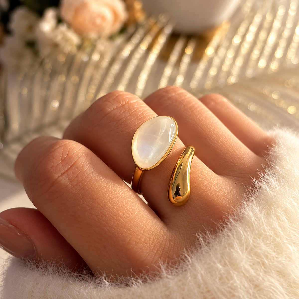 Bague dorée ouverte avec un grand motif ovale blanc aux reflets nacrés et un motif goutte doré