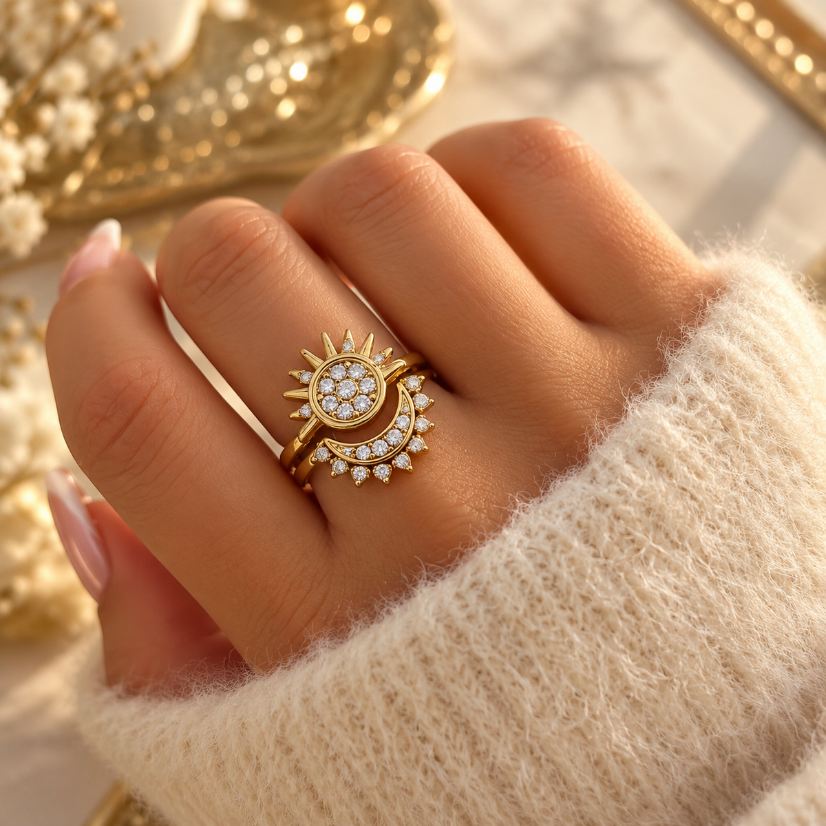 Bague dorée présentant un soleil et un croissant de lune ornés de petites pierres transparentes