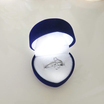 Bague réglable double trèfle argentée présentée dans un écrin bleu