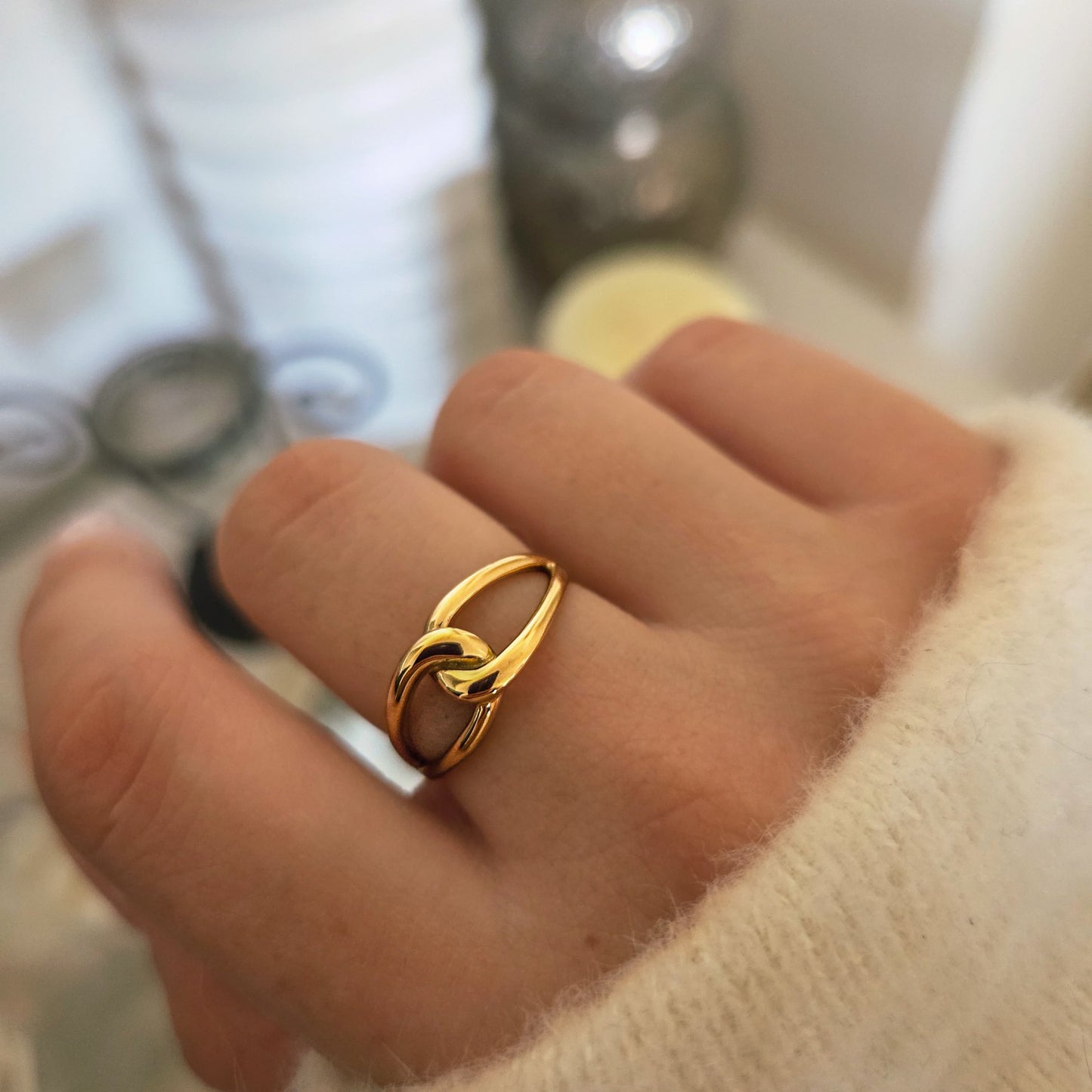Bague dorée entrelacée portée à la main