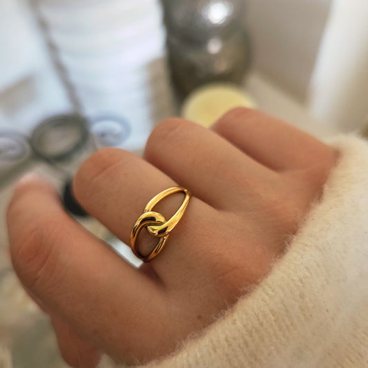 Bague dorée entrelacée portée à la main