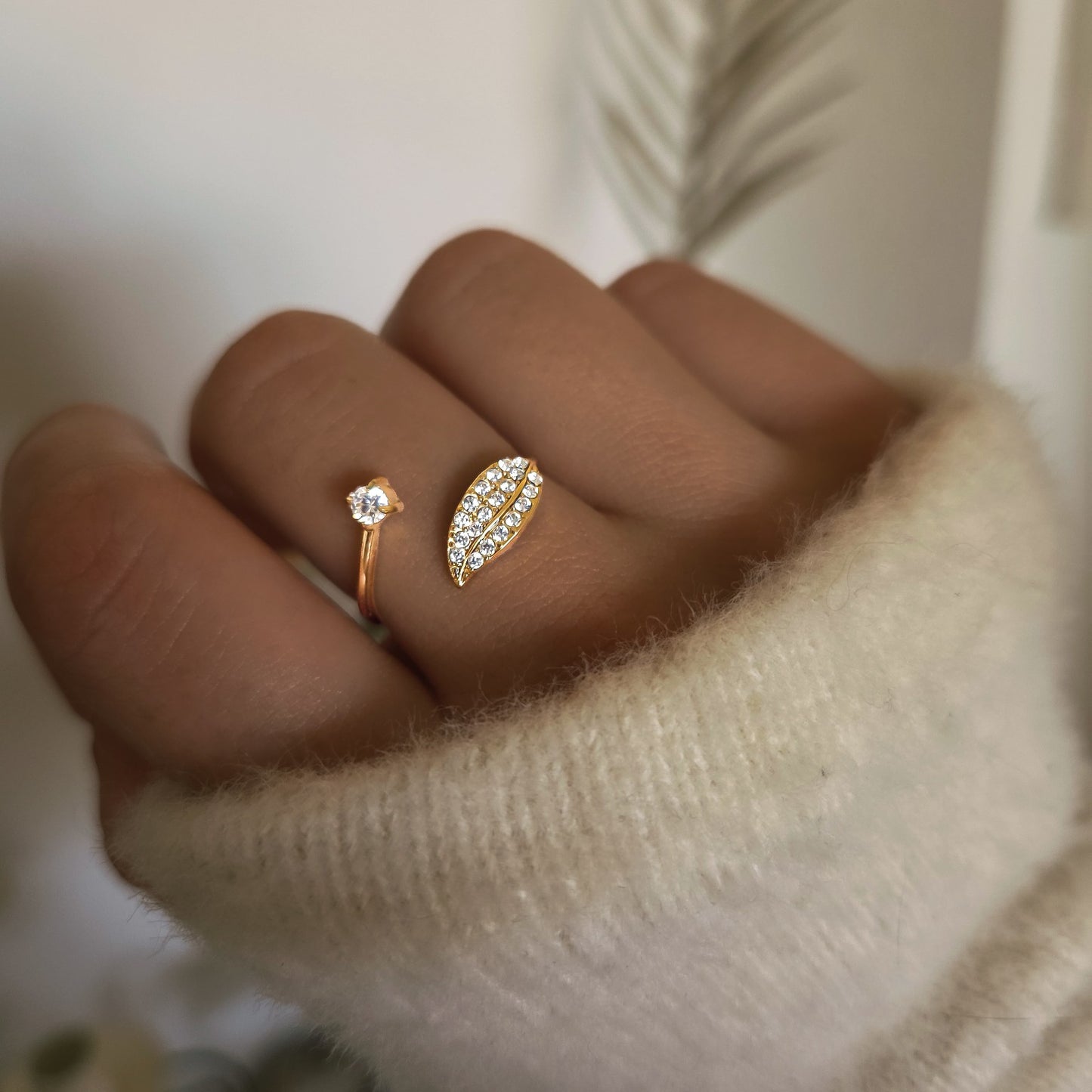 Bague ouverte dorée feuille pavée de strass portée à la main