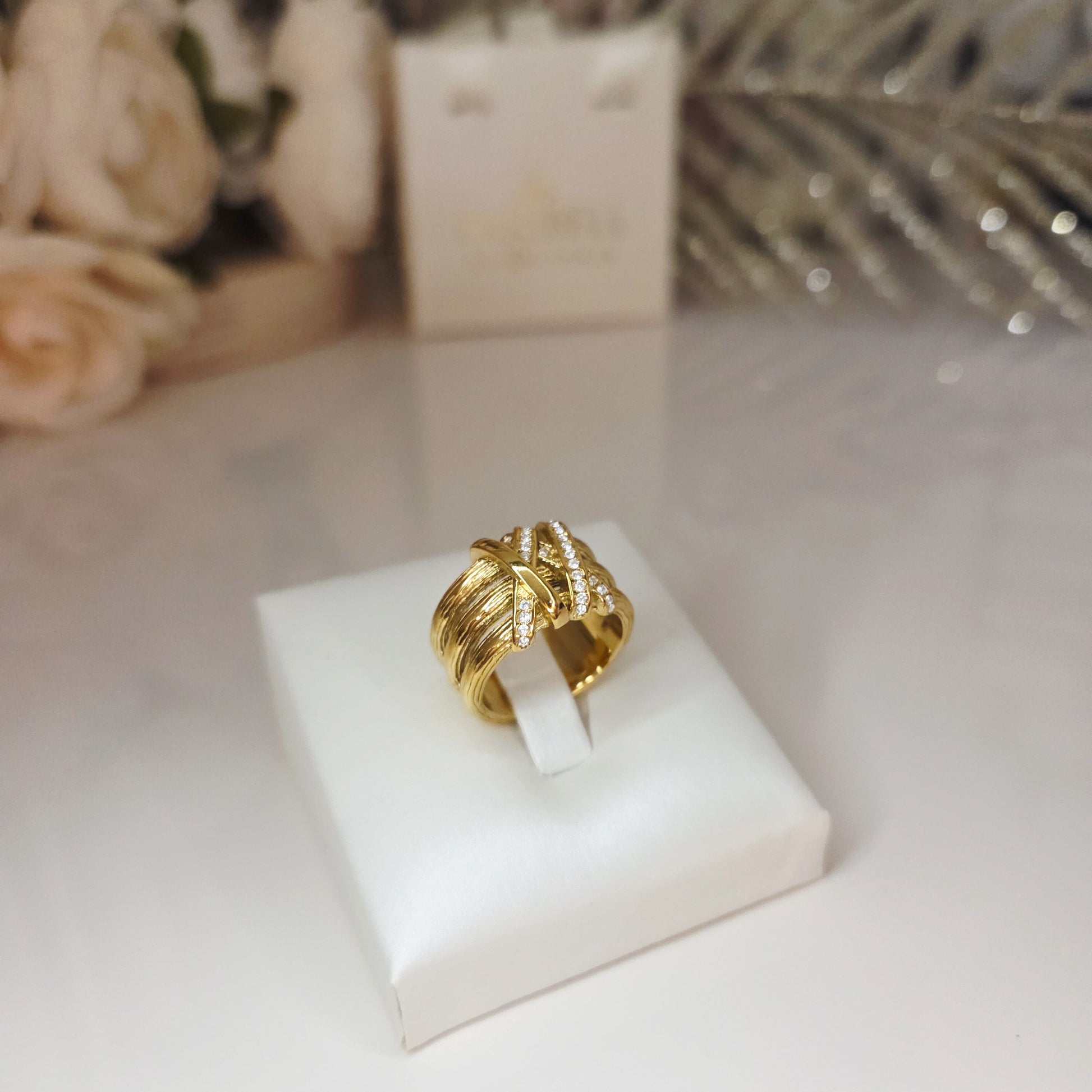 Bague large dorée avec texture travaillée et strass scintillants. Bijou chic et élégant, effet couture.