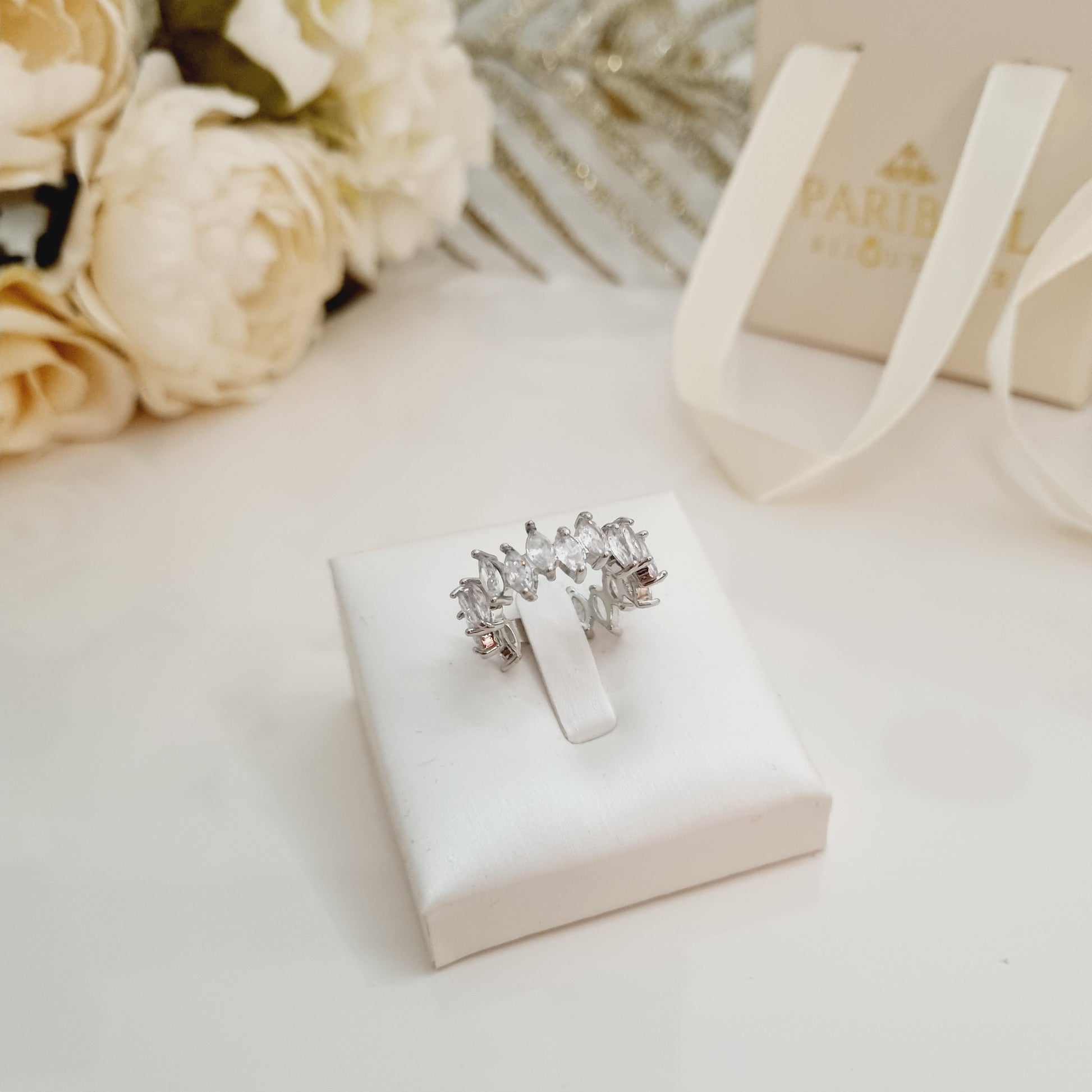 Bague Louna en acier inoxydable doré avec pierres brillantes sur support blanc – Bijou ajustable élégant. Boutique très classe.
