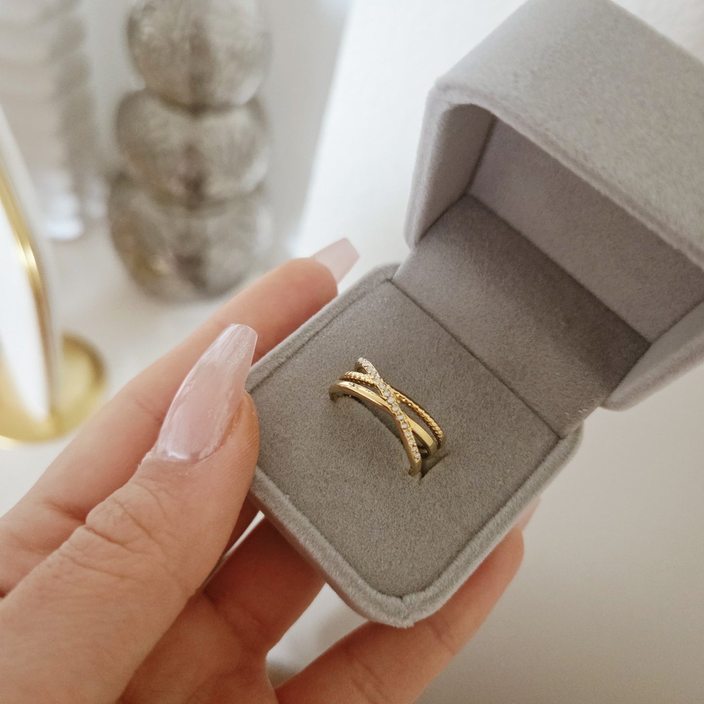 Bague dorée multirangs avec détails pavés présentée dans un écrin