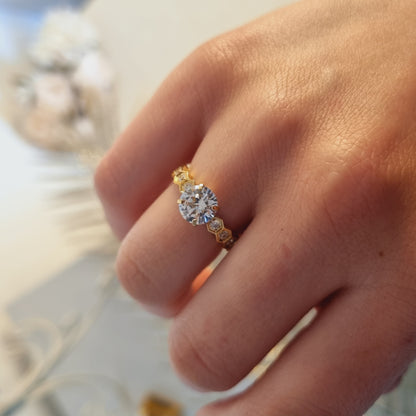 Bague dorée en acier inoxydable, vue portée, avec pierre zirconium ronde et pierres latérales