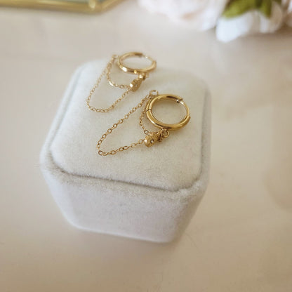 Boucles d'oreilles créoles dorées avec doubles chaînettes et pendentif goutte