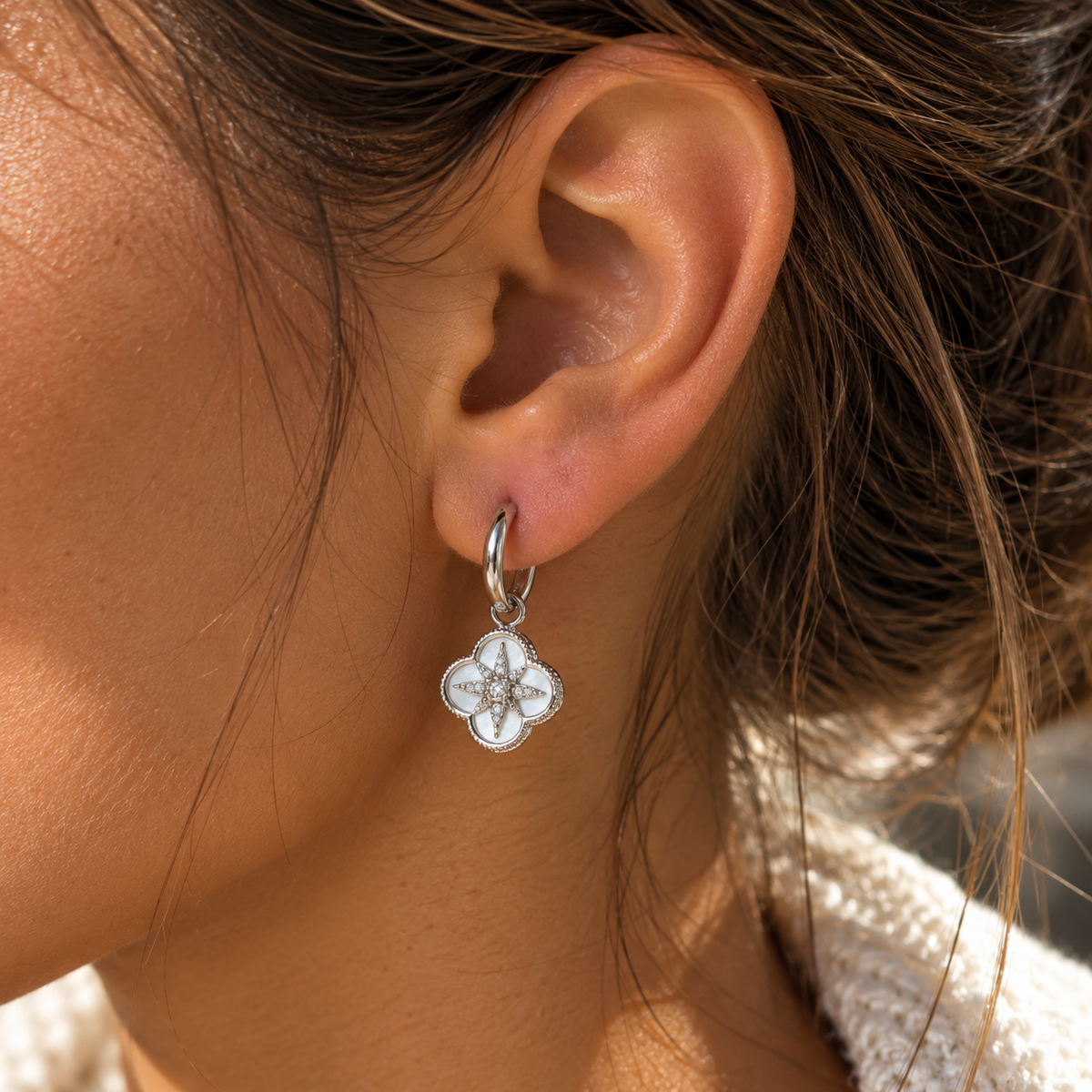Boucles d’oreilles argentées pendantes motif trèfle fleur blanc et cristaux