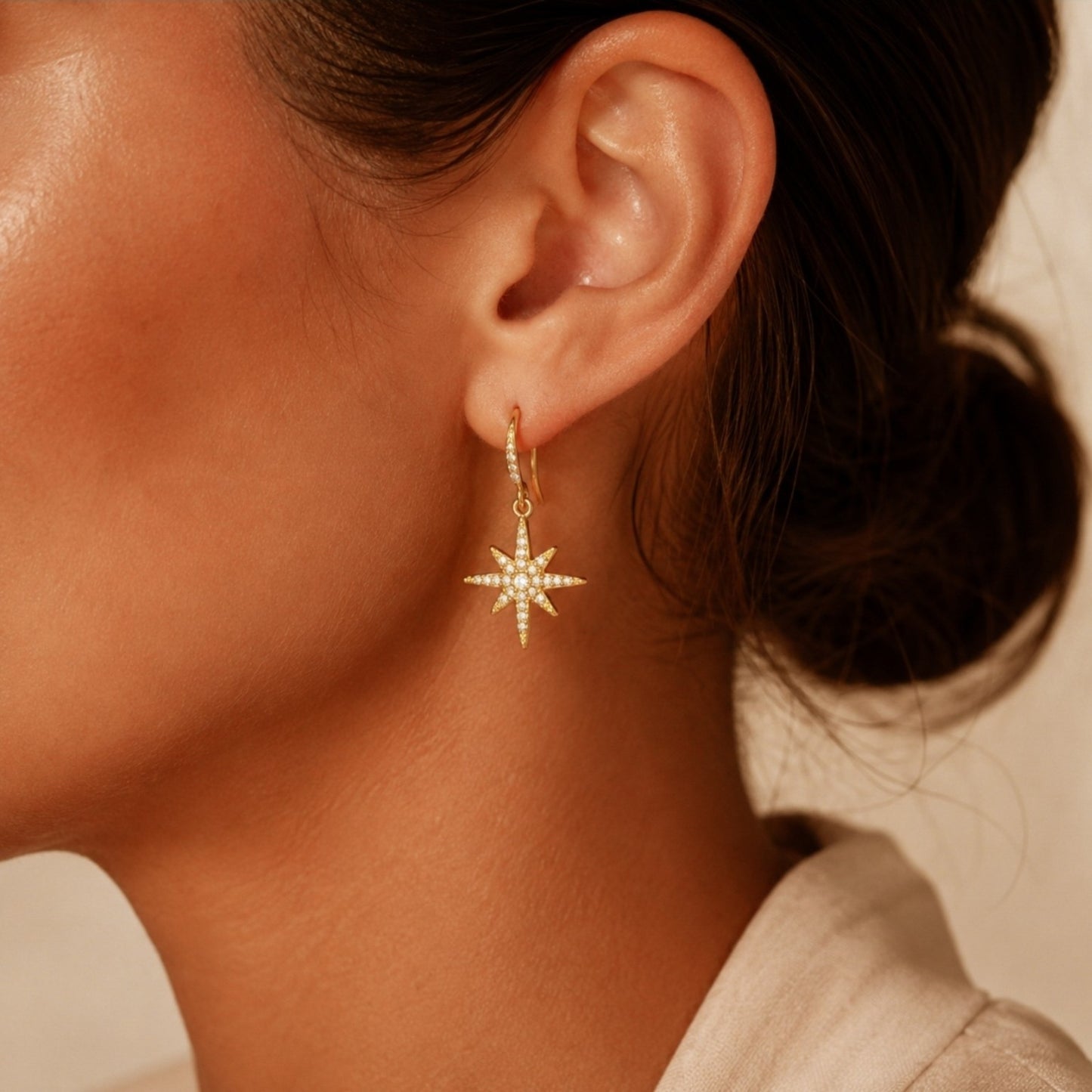 Paire de boucles d’oreilles dorées étoile polaire en acier inoxydable portée à l’oreille