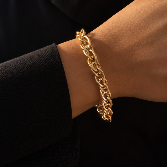 Bracelet chaîne doré à grands maillons ovales entrelacés, porté au poignet