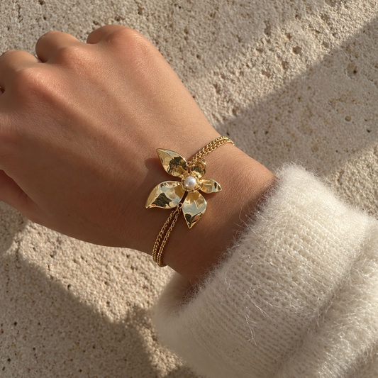 Bracelet doré à chaînes fines et fleur aux pétales texturés avec perle blanche centrale