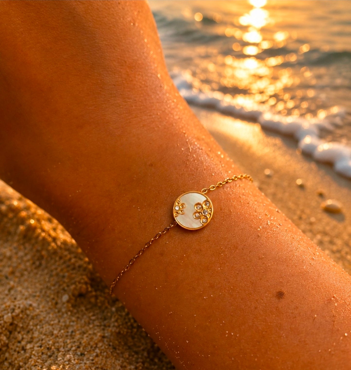 Bracelet doré fin avec médaillon rond nacré orné de motifs floraux