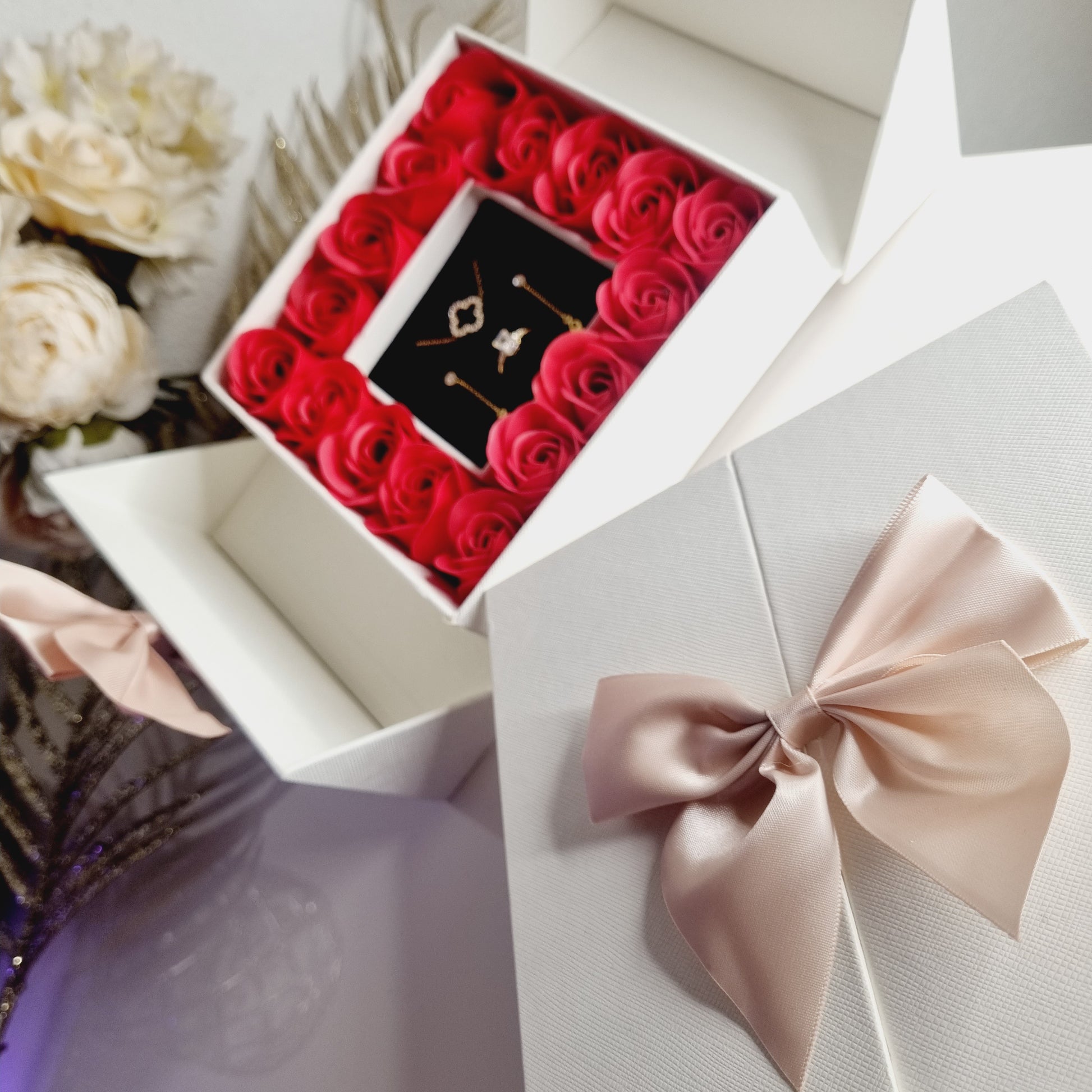 Coffret cadeau avec bijoux dorés et roses rouges
