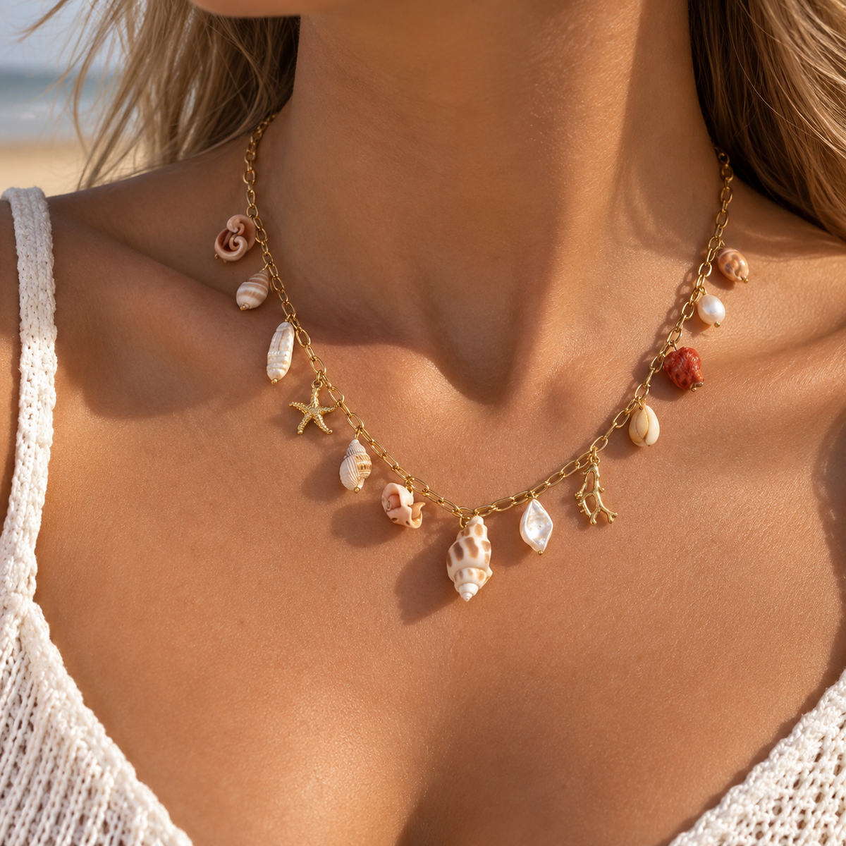 Collier doré à charms coquillages, étoile de mer et corail porté au cou