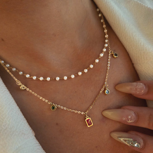 Collier double rang à perles blanches et breloques colorées porté