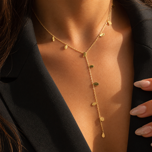 Collier cravate doré en Y avec petites pampilles ovales texturées, porté au cou
