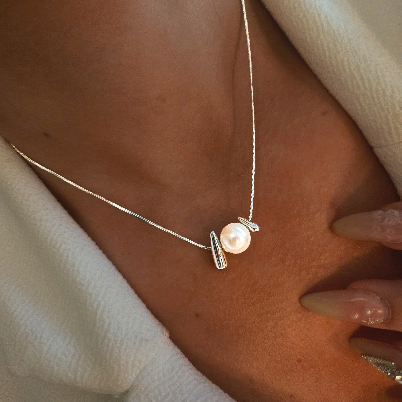 Collier à perle blanche et détails organiques en acier inoxydable porté