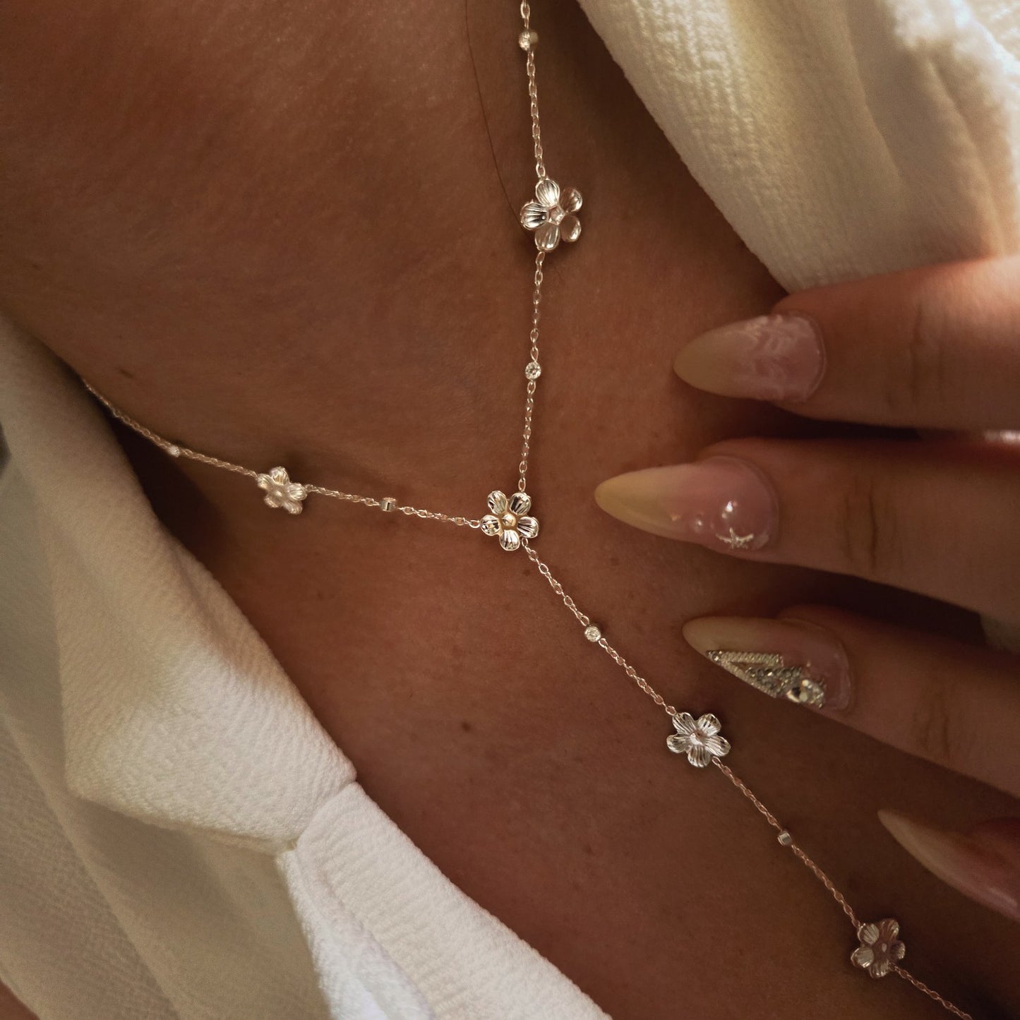 Collier sautoir à fleurs métalliques et pierres brillantes en acier inoxydable porté