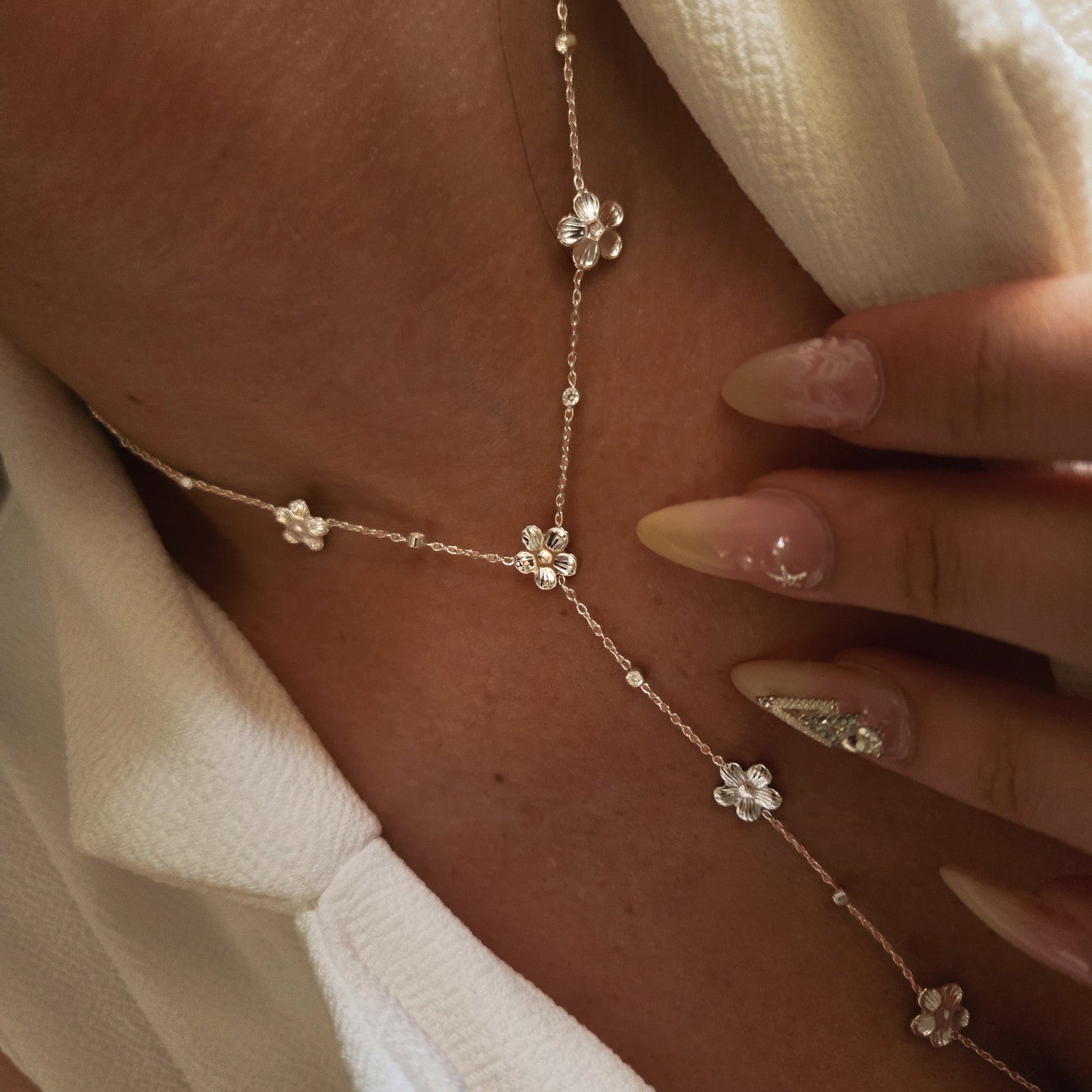 Collier sautoir à fleurs métalliques et pierres brillantes en acier inoxydable porté