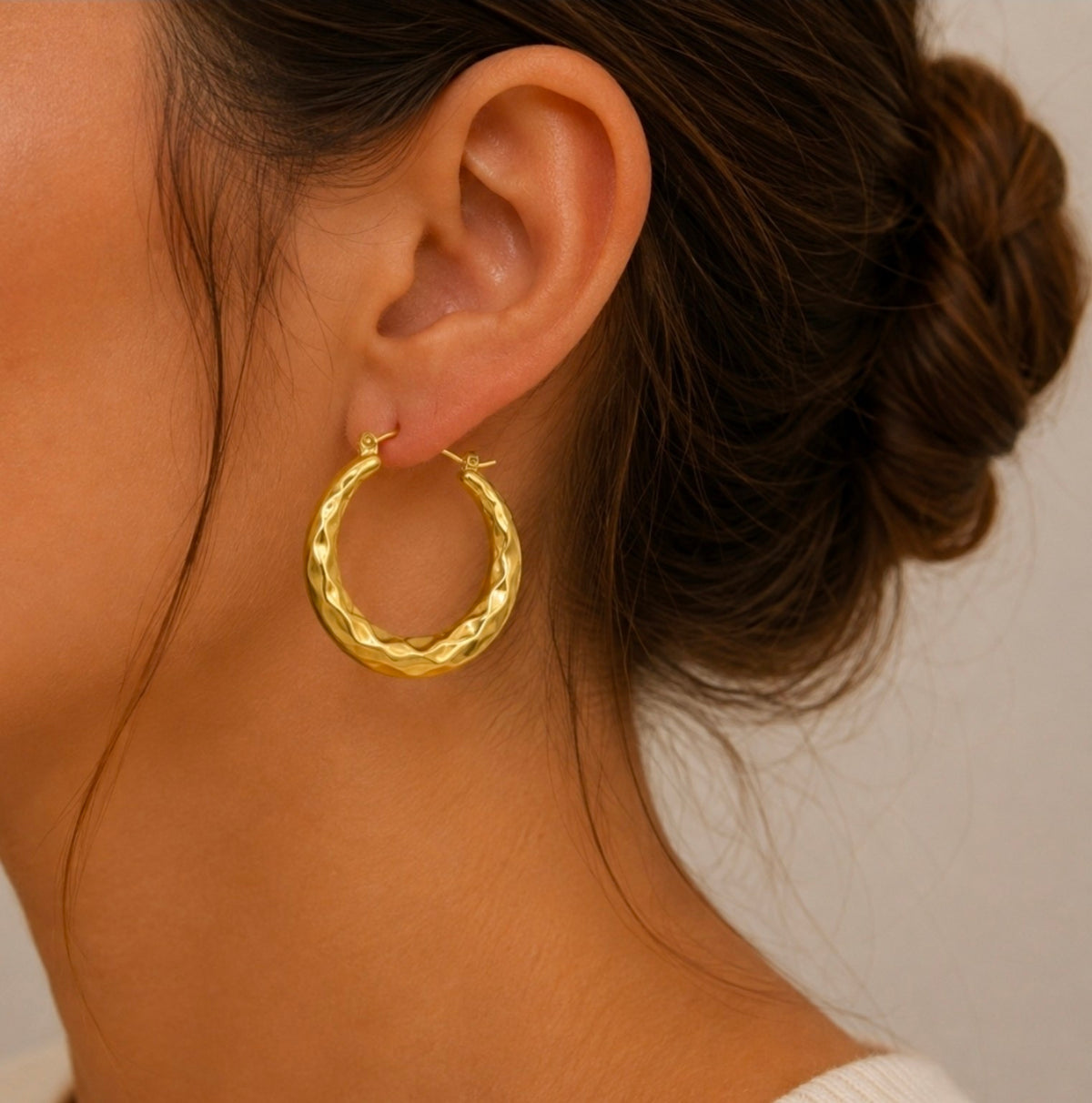 Créole dorée martelée de 3,3 cm portée à l’oreille
