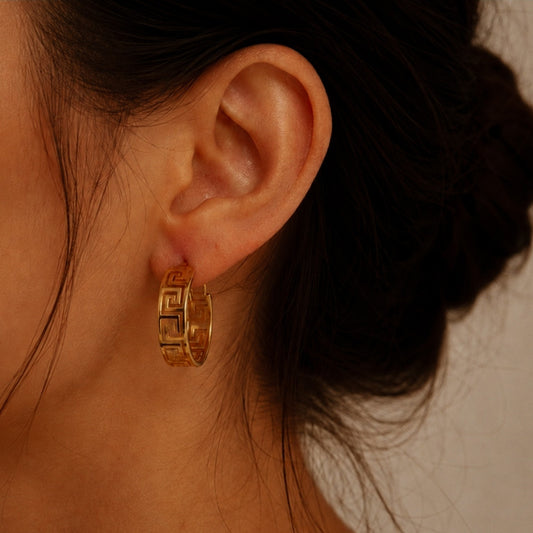 Créole dorée à motif géométrique, 3,2 cm de diamètre et 1 cm de largeur, portée à l’oreille