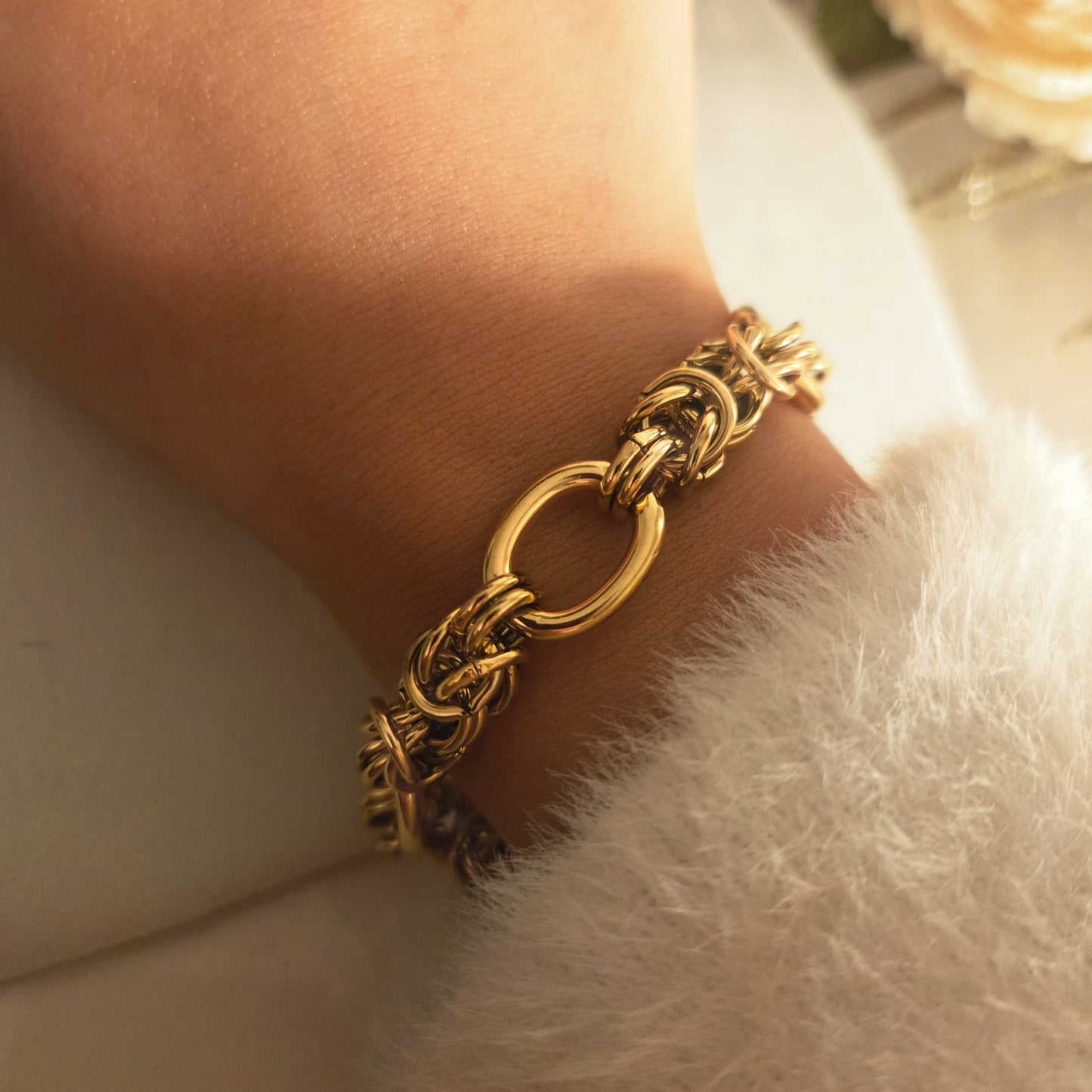 Bracelet à maillons épais doré porté au poignet