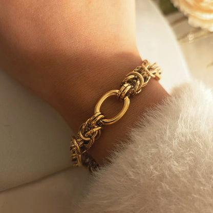 Bracelet à maillons épais doré porté au poignet