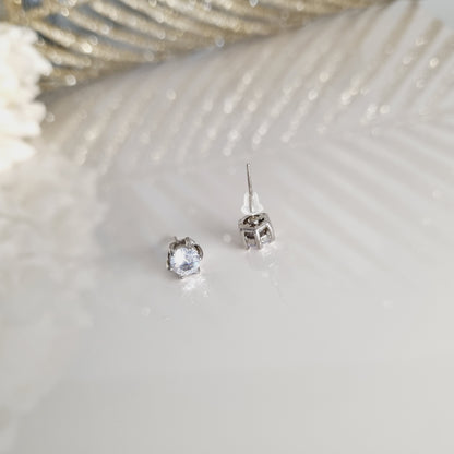 Boucles d’oreilles Estella argentées portées avec pierre brillante