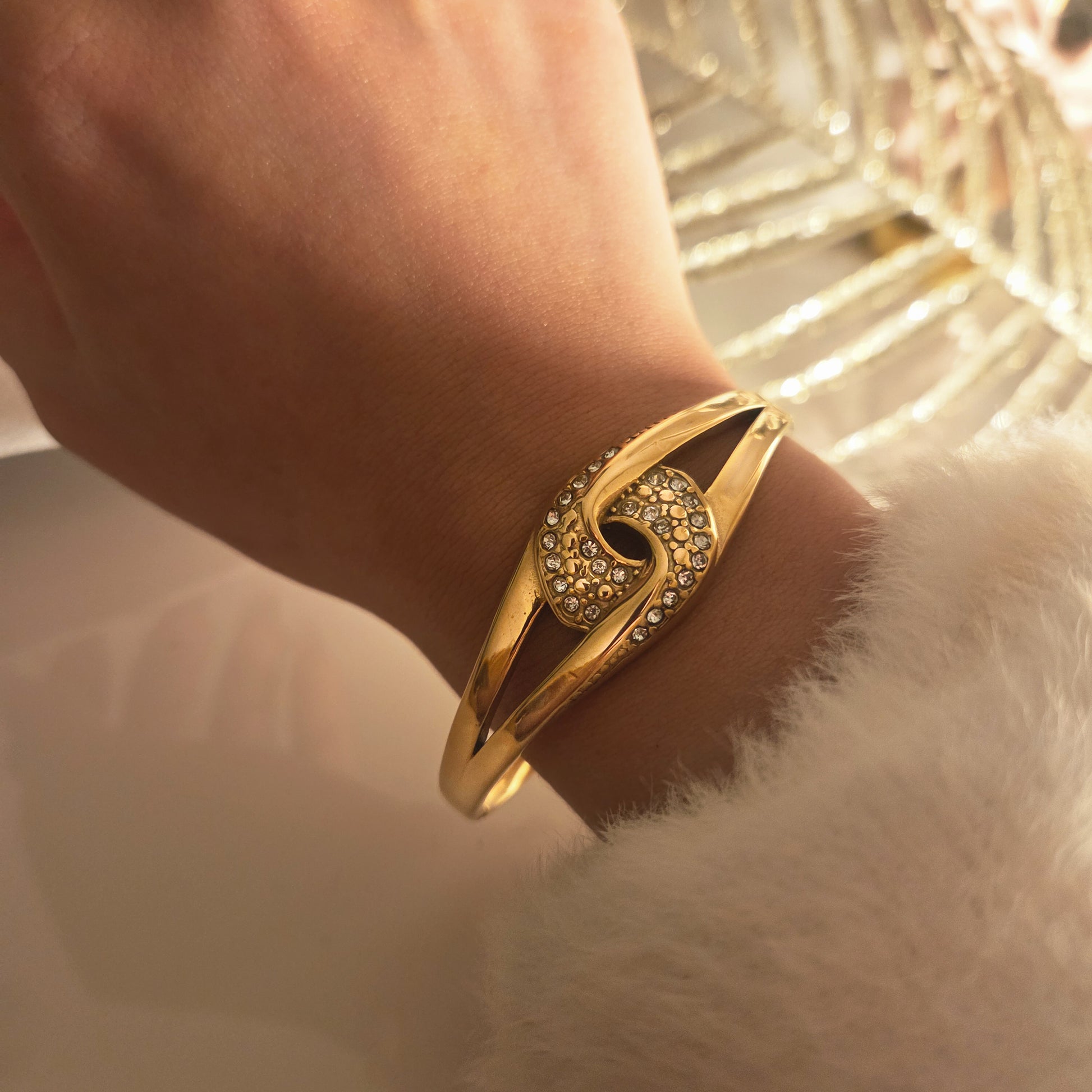 Bracelet jonc œil doré porté au poignet