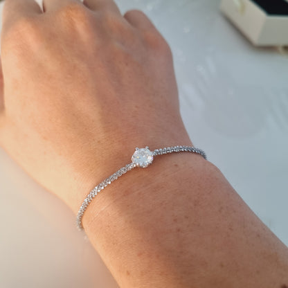 Vue portée du bracelet argenté en argent sterling 925, avec pierre ronde au milieu, pierre précieuse moissanite, la plus brillante du monte. sublimera tous les poignets.