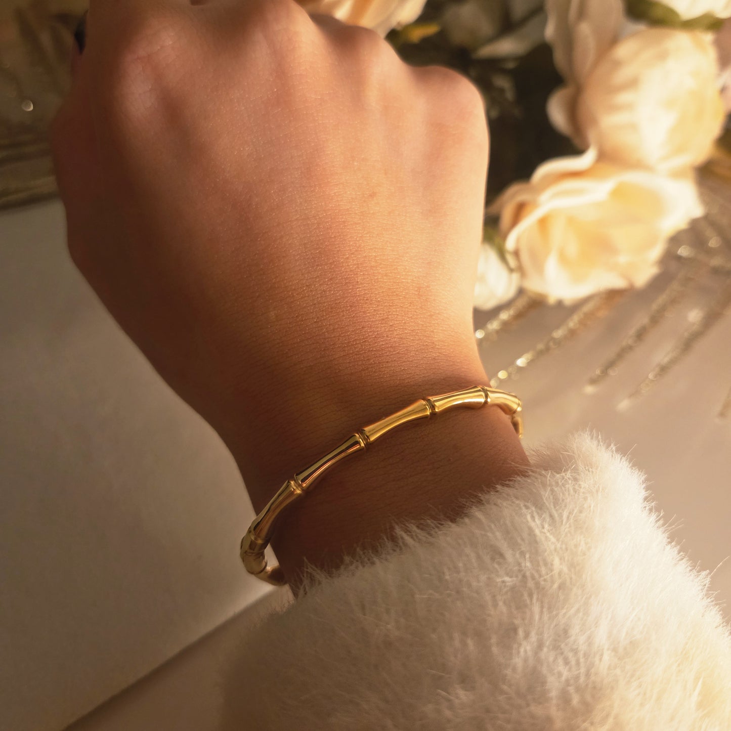 Bracelet jonc bambou doré porté au poignet