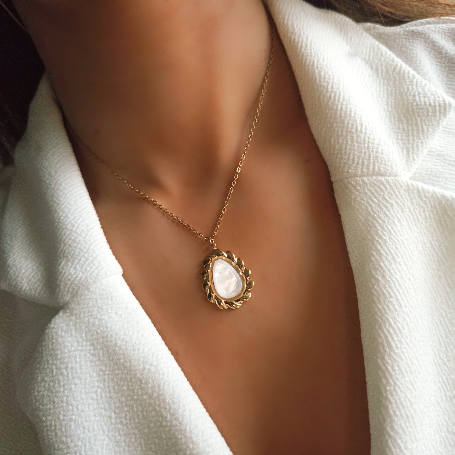 Collier doré et pierre blanche